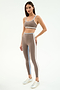 Woman wearing the SPLITS59 Eva Rigor Double Strap Bra in Lentil/White, styled with matching high-waisted leggings and silver sneakers against a white background—ideal for workouts or as a stylish yoga bra.