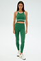 A person wearing the SPLITS59 Layla Airweight Bra in Arugula/Indigo, with matching leggings and white sneakers, stands against a plain background.