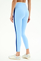 Model wearing SPLITS59 Sam High Waist Rigor 7/8 leggings in Skylight/Cobalt with a dark blue side stripe and silver athletic shoes, shown from the back on a white background.