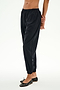 A person wears the SPLITS59 Megan Woven Nylon Jogger in black, featuring a cinched waistband, paired with black ballet flats and standing against a plain white background.