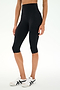A person wearing SPLITS59 Airweight High Waist 16" Capri Legging in black and white sneakers stands against a plain white background.