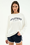 A woman wears the SPLITS59 Andie Oversized Fleece Varsity Graphic Sweatshirt in white with "SPLITS59 LOS ANGELES" print and navy athletic shorts with white trim, standing against a plain light background.