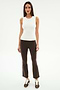 A woman faces forward in the SPLITS59 Raquel High Waist Supplex Crop in Dark Chocolate/White, styled with a sleeveless white top and brown sneakers, standing against a plain white background.