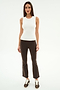 A woman faces forward in the SPLITS59 Raquel High Waist Supplex Crop in Dark Chocolate/White, styled with a sleeveless white top and brown sneakers, standing against a plain white background.