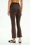 Someone wearing SPLITS59 Raquel High Waist Supplex Crop leggings in Dark Chocolate/White and black-and-white Nike sneakers, shown from the back against a plain white background.