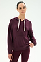 A woman wearing the SPLITS59 Joey Fleece Hoodie in Dark Cherry, featuring white drawstrings and paired with matching leggings, crafted from a soft modal fabric blend, stands against a plain white background.