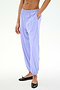 A person wears SPLITS59's Megan Woven Nylon Jogger in Purple Haze, made from stretchy nylon spandex, with hands in pockets and black ballet flats, shown mid-torso down against a plain background.