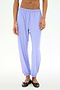 A person wearing SPLITS59's Megan Woven Nylon Jogger in Purple Haze with black ballet flats stands against a plain white background.