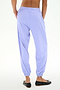 Person wearing SPLITS59 Megan Woven Nylon Jogger in Purple Haze and black ballet flats, shown from the back against a plain white background.