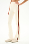 Cream-colored Raquel High Waist Supplex Flare - Creme/Terracotta leggings with a brown and red side stripe, worn with white sneakers.