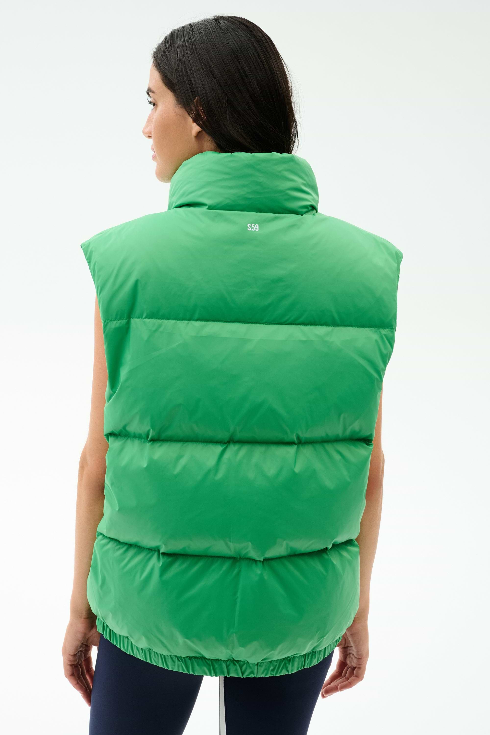 A person is shown from the back wearing the SPLITS59 Summit Nylon Puffer Vest in Grass, featuring "550" on the upper back—ideal for cool weather workouts—standing against a plain light background.