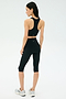 A woman stands on a white background, shown from the back, wearing a black sports bra and SPLITS59 Airweight High Waist 16" Legging in black with silver athletic shoes.