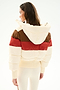 A woman faces away, wearing the SPLITS59 Aspen Puffer Jacket - Creme/Terracotta with cream leggings.