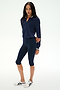 A woman stands on a plain white background wearing the SPLITS59 Bonnie Knit Half Zip in indigo/white, navy knee-length rayon leggings, and white sneakers.