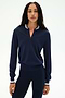 A woman stands facing forward against a plain white background, wearing the SPLITS59 Bonnie Knit Half Zip in Indigo/White—featuring a striped collar and cuffs, crafted from a soft nylon-rayon blend—paired with matching navy leggings.