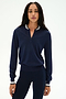A woman stands facing forward against a plain white background, wearing the SPLITS59 Bonnie Knit Half Zip in Indigo/White—featuring a striped collar and cuffs, crafted from a soft nylon-rayon blend—paired with matching navy leggings.