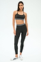 A woman poses in SPLITS59’s Bailey Active Rib High Waist 7/8 set in Heather Graphite, featuring a matching ribbed sports bra and leggings with white stripe accents, paired with white sneakers—ideal for gym workouts.