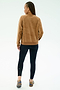 A person with braids wears the SPLITS59 Joy Velour Crewneck in Honey and black stretch leggings, standing with their back to a light background.