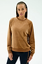 A woman with braided hair wears the SPLITS59 Joy Velour Crewneck in Honey, paired with dark side-striped stretch pants, standing against a plain light background.