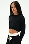 A woman with long braided hair wears the SPLITS59 Noah Fleece Crop Sweatshirt in black and matching pants with a white drawstring, standing against a white background. This dance-inspired look is made in Los Angeles.