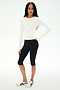 A woman wears the SPLITS59 Airweight Lite Long Sleeve Waist Length tee in white, paired with black knee-length leggings and white sneakers, standing against a plain white background—an ideal outfit for gym workouts.