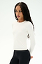 A woman with long braided hair wears the SPLITS59 Airweight Lite Long Sleeve Waist Length top in white paired with black leggings, standing against a plain white background and looking to the side—an ideal choice for quick-dry comfort during gym workouts.
