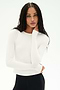 A person with long braided hair models the SPLITS59 Airweight Lite Long Sleeve Waist Length tee in white, paired with black pants, posing with one hand touching their face against a plain white background.