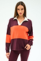 A woman with straight brown hair wears the SPLITS59 Katie Fleece Rugby in Dark Cherry/Valencia, paired with burgundy pants, standing against a plain light background.