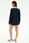 A person faces away wearing the SPLITS59 Andie Oversized Fleece Varsity Graphic Sweatshirt in indigo, navy shorts with white trim, and white Adidas sneakers with navy stripes.