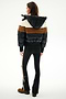 Woman faces away wearing SPLITS59 Aspen Puffer Jacket - Black/Toffee, black side-stripe pants, and brown shoes against a plain background.