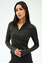 A woman with long dark hair wears the SPLITS59 Stevie Active Rib Half Zip Waist Length top in Heather Graphite, standing against a plain light background.