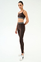 Wearing SPLITS59's Bailey High Waist Active Rib 7/8 leggings in Heather Dark Chocolate, styled with a matching sports bra and white sneakers, she poses against a white background—ideal for gym workouts.