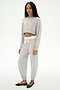 A woman wears the SPLITS59 Noah Fleece Crop Sweatshirt in Heather Grey with matching sweatpants and black flats, standing against a plain white background.