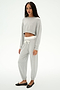 A woman wears SPLITS59’s Andie Dual Waist Sweatpant in Heather Grey/White—a soft, cropped jogger crafted from a modal-spandex blend—paired with black flats, set against a plain white background.