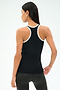 A woman is seen from the back wearing the SPLITS59 Ashby Rib Tank in Black/White with dark leggings, standing against a plain backdrop.