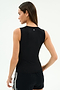 A woman facing away wears the SPLITS59 Carter Airweight Lite Tank in black with black spandex shorts featuring white stripes, set against a plain light background.