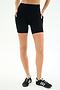 A person wears SPLITS59 Airweight High Waist Pocket Short 6” in black with side pockets and black sneakers, standing against a plain white background.