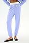 Person wearing SPLITS59 Andie Dual Waist Sweatpant in Purple Haze/White, featuring a white drawstring and stretchy fabric, paired with black ballet flats, shown from waist to feet against a plain background.