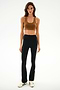 Woman in a brown sports bra, white sneakers, and SPLITS59 Raquel High Waist Supplex Flare - Black/Creme against a white background.