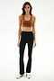 Woman in a brown sports bra, white sneakers, and SPLITS59 Raquel High Waist Supplex Flare - Black/Creme against a white background.
