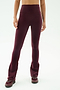 A person wearing SPLITS59 Raquel High Waist Flared Legging in Dark Cherry/Creme, paired with matching burgundy athletic shoes, shown from shoulders down against a plain background.