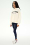 A woman stands against a plain white background wearing the SPLITS59 Stella French Terry Oversized Hoodie in Creme/Splits59 Los Angeles, paired with navy leggings and white sneakers.