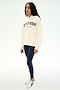 A woman stands against a plain white background wearing the SPLITS59 Stella French Terry Oversized Hoodie in Creme/Splits59 Los Angeles, paired with navy leggings and white sneakers.