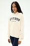A woman with long braids wears the SPLITS59 Stella French Terry Oversized Hoodie in Creme/Splits59 Los Angeles—a soft 100% cotton sweatshirt featuring signature "SPLITS59 LOS ANGELES" text—paired with dark leggings, standing against a plain white background.