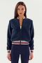 A person with long hair is wearing the Willa Sherpa Jacket - Indigo by SPLITS59, standing against a plain white background.