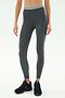 Wearing SPLITS59’s Bailey Active Rib High Waist 7/8 leggings in Heather Grey—featuring a white-striped waistband and textured rib fabric—paired with black sneakers, ideal for gym sessions against a minimal light backdrop.