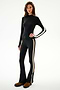 A woman models the Isabelle Airweight Lite Mock Neck - Black/Creme by SPLITS59, featuring long sleeves and flared pants, against a plain white background.