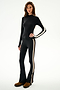 A woman models the Isabelle Airweight Lite Mock Neck - Black/Creme by SPLITS59, featuring long sleeves and flared pants, against a plain white background.