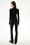 A person faces away wearing the SPLITS59 Isabelle Airweight Lite Mock Neck - Black/Creme, black side-striped pants, and brown shoes against a plain white background.