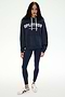 A person stands against a plain light background wearing the SPLITS59 Stella French Terry Oversized Hoodie in Indigo, featuring "SPLITS59 Los Angeles" branding, paired with navy leggings and white sneakers.